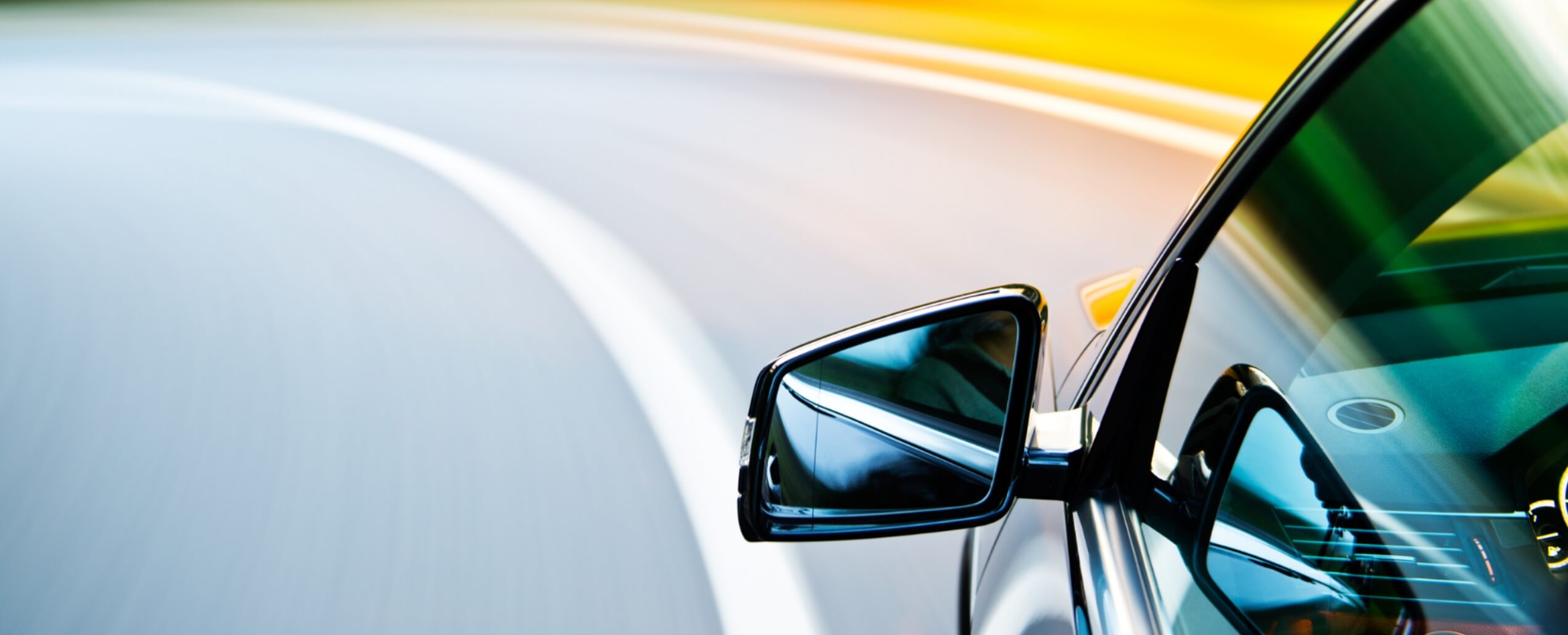 走行している車のサイドミラーの画像